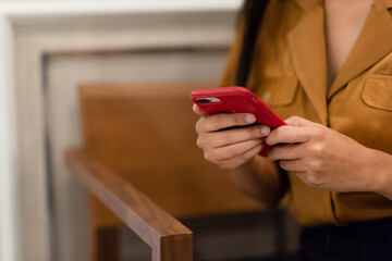 Closeup of a business woman in casual clothes reading the news from a smartphone.