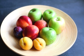 Wooden bowl with various colorful fruit. Selective focus.