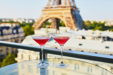Two Cosmopolitan cocktails in traditional martini glasses with view to the Eiffel tower, Paris,...