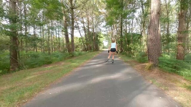 beautiful young woman inline skating on the bike path