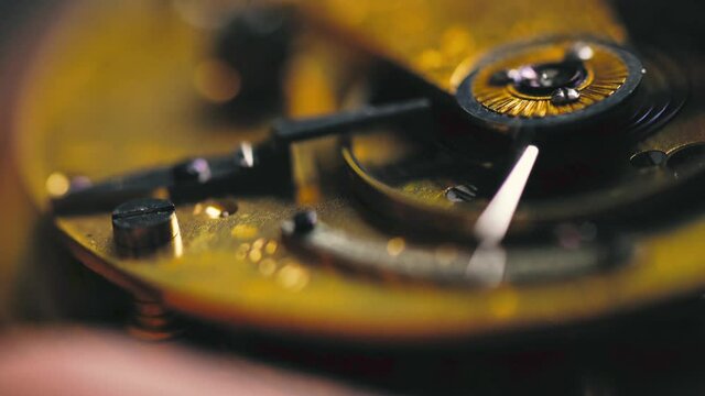 Inspecting the movement on a vintage Fusee pocket watch.