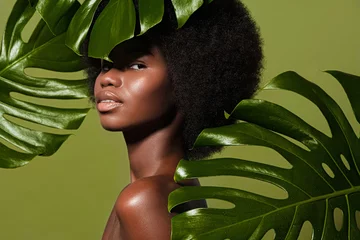 Door stickers Beauty salon Green beauty portrait of young beautiful african american woman with posing against green exotixc plants  background. Natural skin care concept
