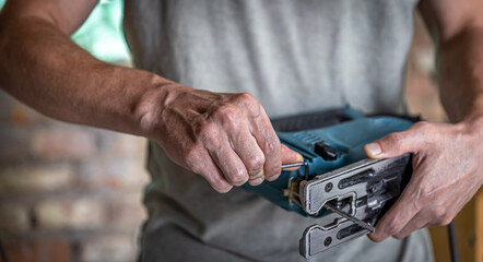 Close up electric tool for sawing wood in hands of man.