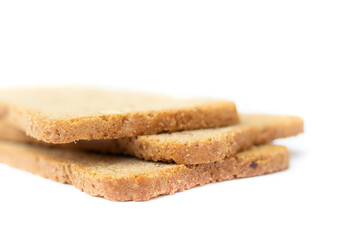 Twice toasted wheat bread crackers. Close up of three thin rectangular shaped bread slices toasted and re-toasted. Low calorie snack with fiber ideal for dieting. Isolated on white. Selective focus.