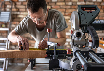 Professional carpenter working with a miter saw.