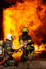 Firefighters are conducting fire drills by spraying water to extinguish the raging fire.