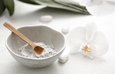 Spa composition with powder face mask and orchid flower.