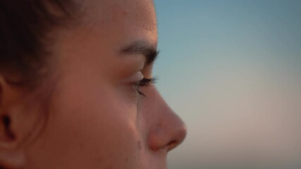 Girl's look forward. Blinking female eye with long eyelashes, macro, side view. Concept of confidence