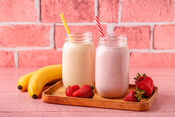Strawberry and banana milkshakes in glass jars