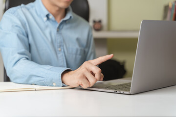 Young businessman, investor or trader pointing on laptop when trading, investing on online stock market or Cryptocurrency as Bitcoin trading platform. Young business money trader, investor concept