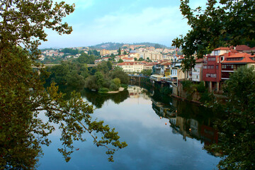 Fototapeta na wymiar Reflections over the Tamega River in its pass through Amarante town in northern Portugal