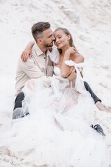 Beautiful wedding couple bride and groom at wedding day outdoors at ocean beach. Happy marriage couple o