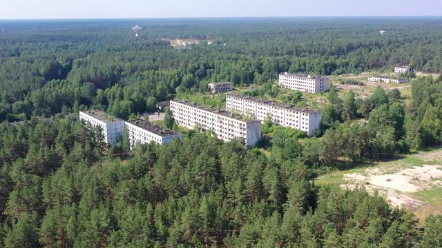 Aerial view orbiting around abandoned soviet military town Irbene in Latvia. Radio telescope in background