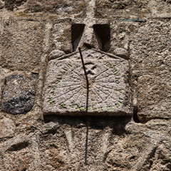 Vieux cadran solaire en pierre surmonté d'une croix