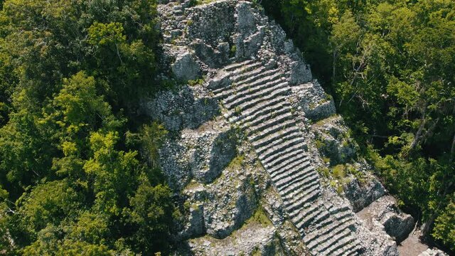 Aerial view of Ancient Mayan pyramid and Coba ruins in Mexico. Landscape panorama of Quintana Roo Peninsula from aboveL. Lush jungle on a sunny day, 4k UHD.