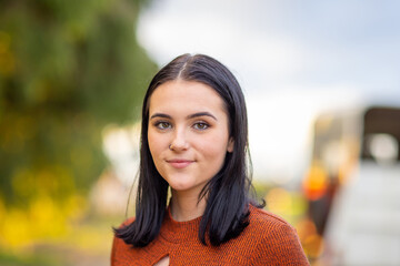 head and shoulders of dark haired teenage girl looking at camera