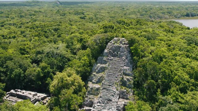 Aerial view of Ancient Mayan pyramid and Coba ruins in Mexico. Landscape panorama of Quintana Roo Peninsula from aboveL. Lush jungle on a sunny day, 4k UHD.