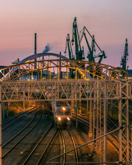 train against port cranes in gdansk 