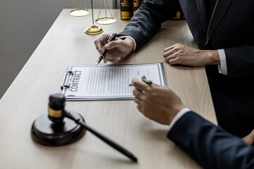 Two male lawyers are consulting together to draft a contract acknowledgment for their clients, they...
