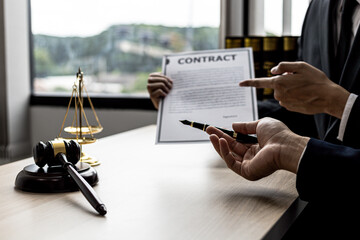 Two male lawyers are consulting together to draft a contract acknowledgment for their clients, they...