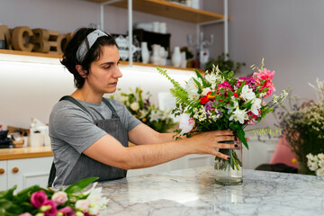 Florist preparing a bunch of flowers for a client