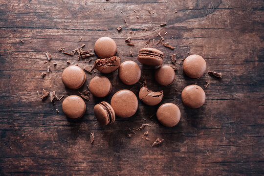 Chocolate macarons lying on wooden table