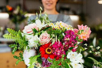 Crop woman holding a bouquet of roses in a florist