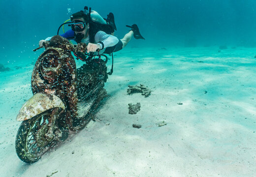 diver posing on motorbike on the ocean floor at Phuket