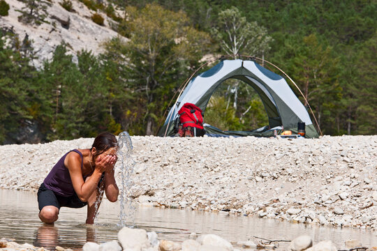 Woman washing her face at remote camp site in the Verdon canyon