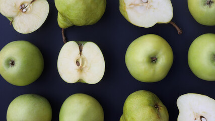 whole and cut apples and pears on a dark background