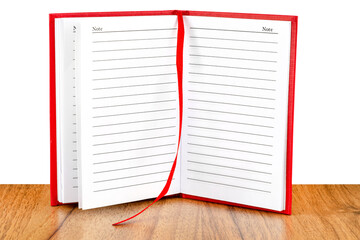 Open red lined notebook standing on a wooden table, isolated on a white background.