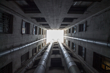 Obraz premium Bottom-up view from the courtyard-well of a historic house with closed walls in St. Petersburg Russia