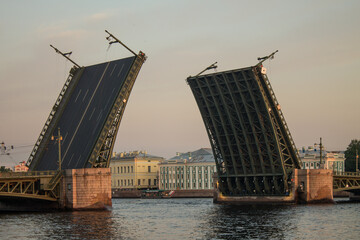 Fototapeta na wymiar Saint Petersburg, Russia-July, 15, 2021: a dilute palace bridge and a view of the university embankment with historical buildings in the early summer morning and copy space