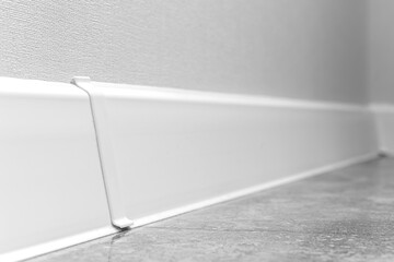 White skirting boards close-up, modern apartment interior design background wit selective focus...