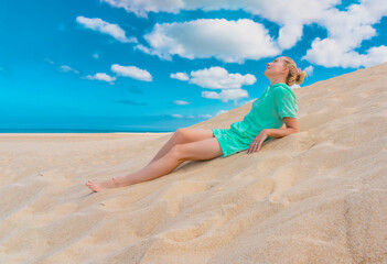 Beautiful woman relaxing on the sand against the background of the sky. Woman lying on the nature. Relax, meditation concept. Hight quality photo