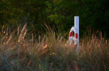 Versteckter rot-weißer Rettungsring am Strand im Süden der dänischen Ostsee-Insel Bornholm