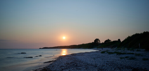 Sommerlicher Sonnenuntergang am Stand im Süden der dänischen Ostsee-Insel Bornholm in der Nähe...