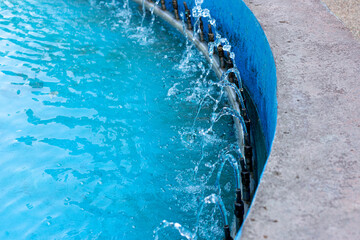 Water flows from pipes with a fountain of blue color, water splashes from the fountain