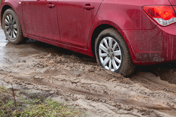 Car stuck in the mud, car wheel in dirty puddle, rough terrain - obrazy, fototapety, plakaty