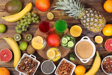 Assorted fresh summer tropical fruits, vegetables and nuts on bright sunny table, citrus mix, detox diet and weight loss concept, banner, store advertisement, healthy and natural food