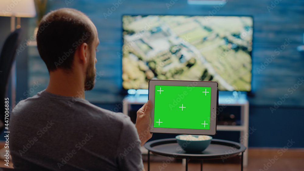 Poster person using modern tablet horizontally for green screen display in living room at home. user of chr