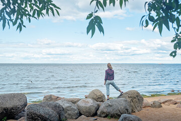 Woman looks at the Gulf of Finland in the park of the city of Peterhof in Russia