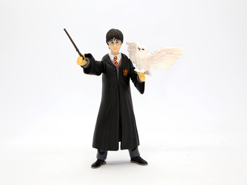 Harry Potter with his white owl Hedwig. Harry dressed in his Hogwarts School of Witchcraft and Wizardry uniform and his wand in hand. Collectible toy for children. Character from the J. K. Rowling.