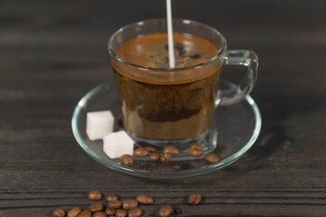 Zalewanie zaparzonej czarnej kawy mlekiem. - obrazy, fototapety, plakaty