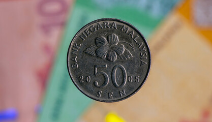 50 sen coins on blurred background of Ringgit Malaysia banknote, selected focus © JakaSuryanta