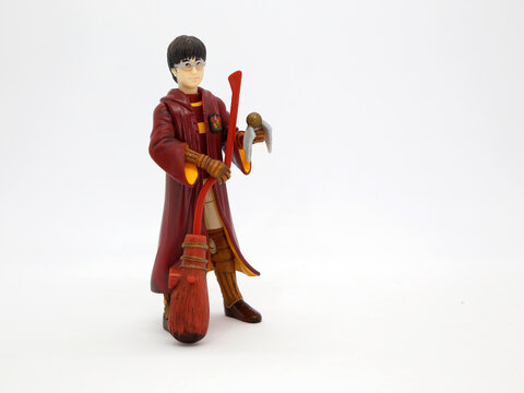 Harry Potter Dressed In Hogwarts School Uniform Of Quidditch Game. Collectible Toy For Children. Character From The J. K. Rowling. Broom. Golden Snitch Ball.