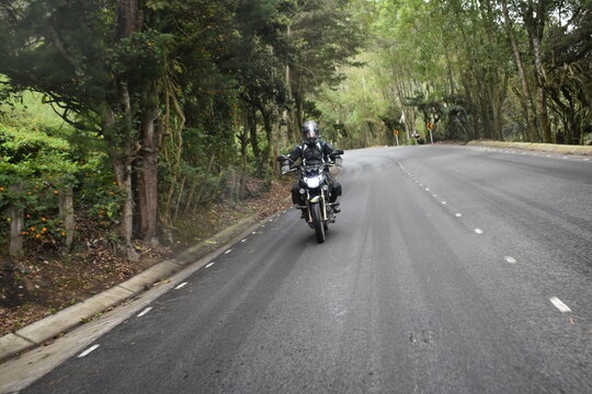 young man riding a motorcycle on the road 