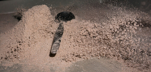 Spoon falling over cocoa powder