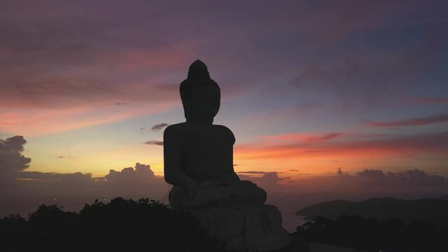 .aerial view scenery silhouette of Phuket big Buddha colorful sky in twilight background..Another incentive to attract tourists to visit. 4k video for travel and worship concept..