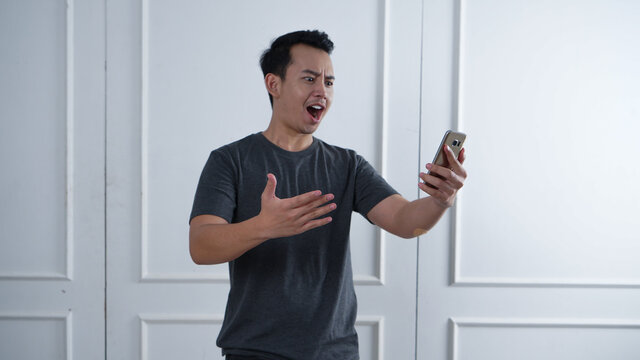 Asian man yelling on his phone
